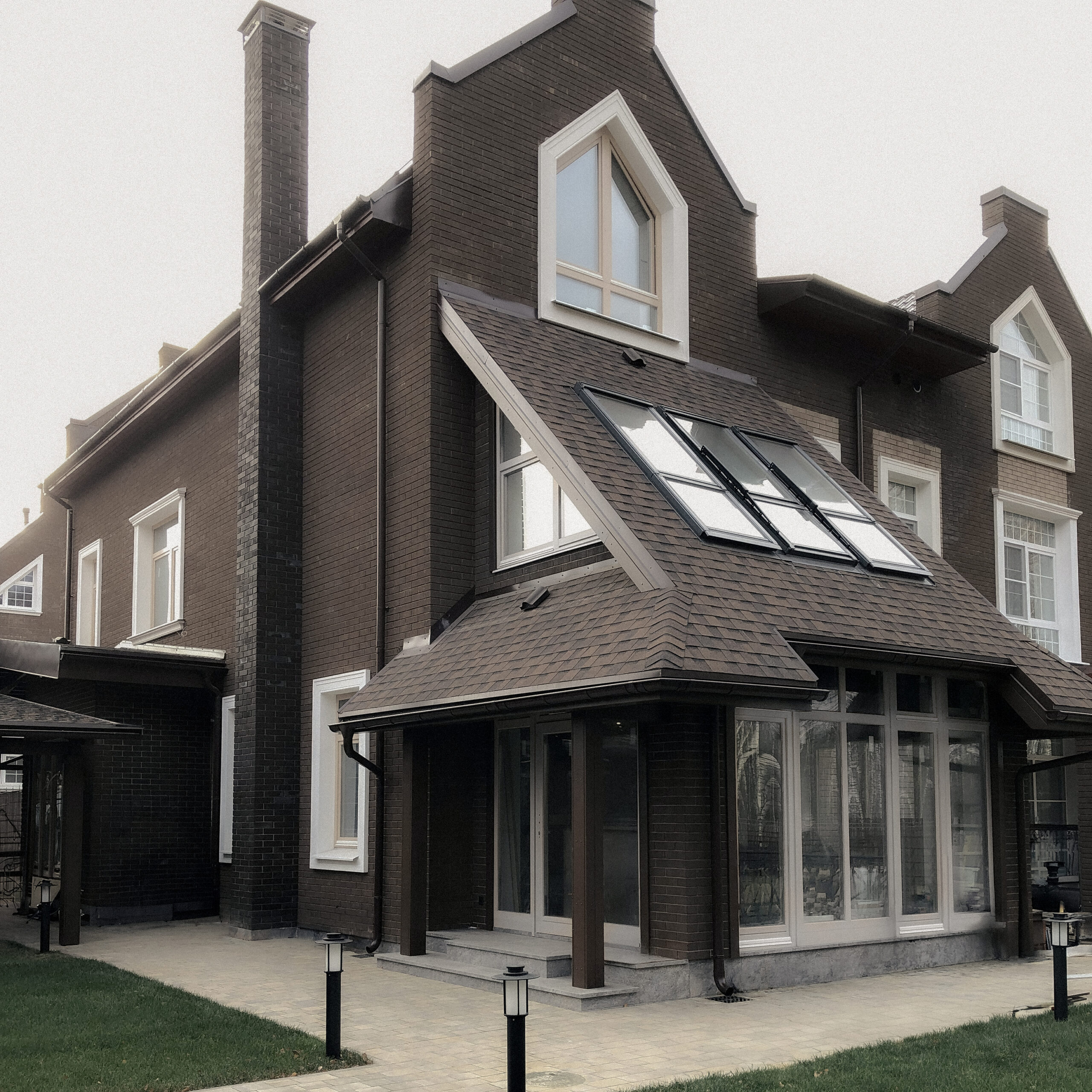 Completed brick residence with added third level and sloped glazed veranda, UK