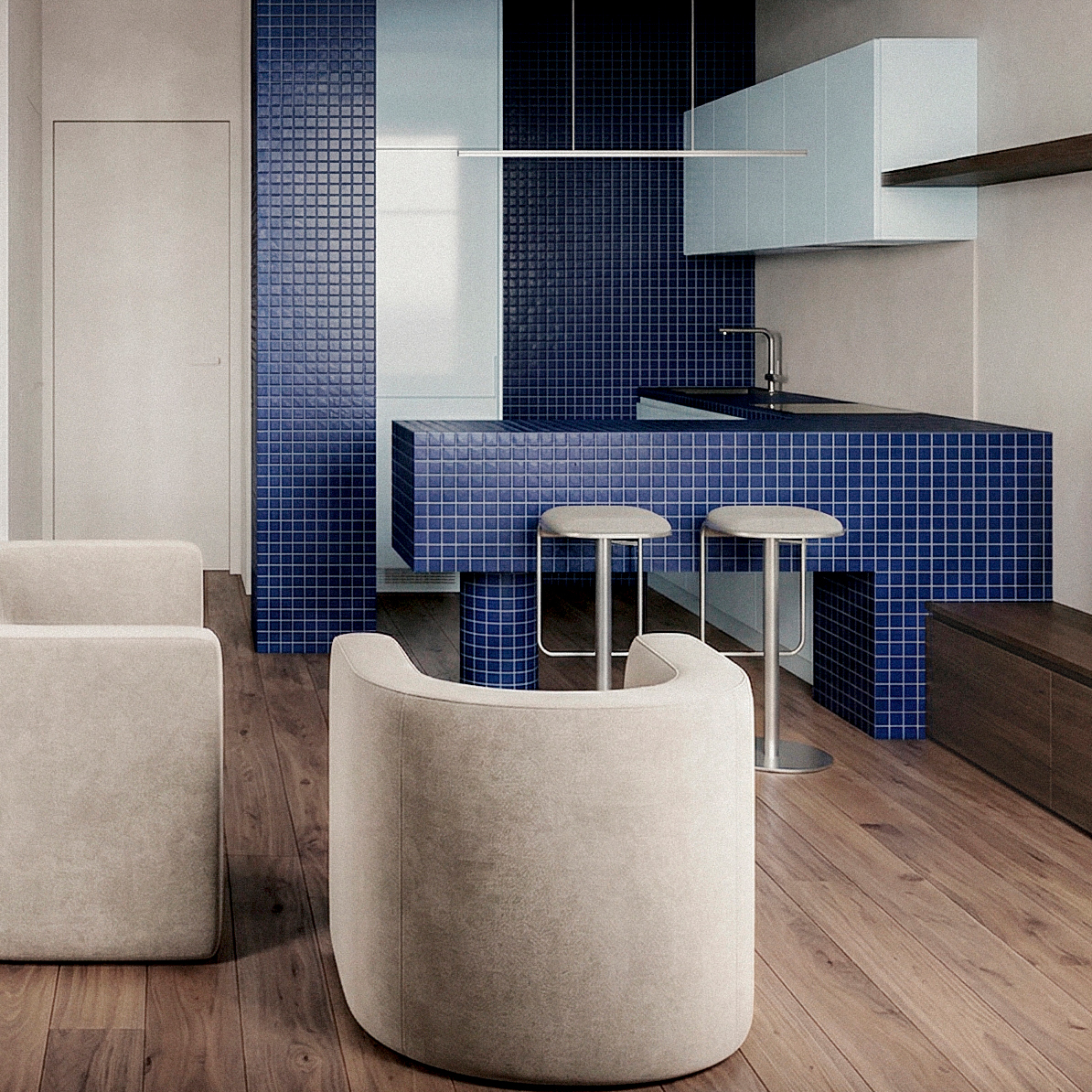 Cucina aperta con isola e rivestimento in mosaico blu, integrata nello spazio principale dell’appartamento. Open kitchen with island and blue mosaic finish, integrated into the apartment’s main living space.