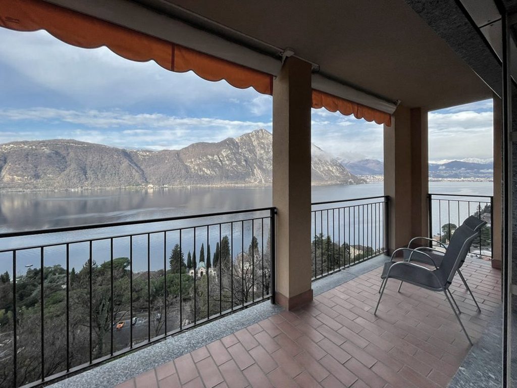 Vista panoramica sul Lago di Lugano e sulle montagne dalla terrazza dell’appartamento a Campione d’Italia. Panoramic view of Lake Lugano and the surrounding mountains from the apartment terrace in Campione d’Italia.